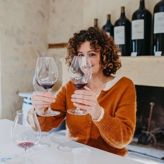 Frau vergleicht zwei Gläser Rotwein bei einer Weinprobe